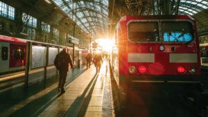 people and train at a train station in direct sunlight